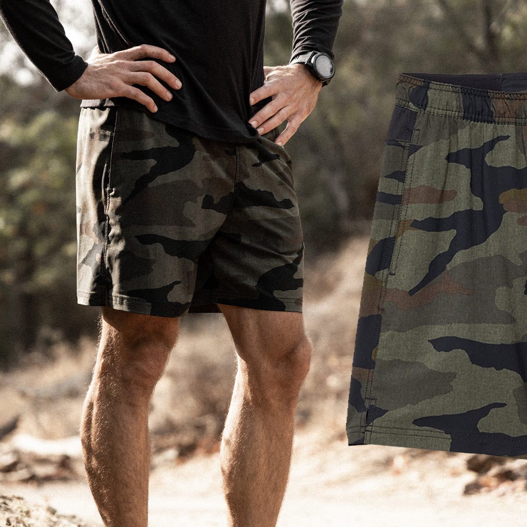 Man with hands around hip wearing the Forcis Standard Issue 6.5 lined shorts in camo.